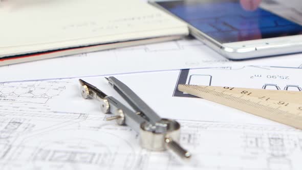 Engineer Looks at the Data for the Drawing in the Phone and Writes Them Down. Close Up alt