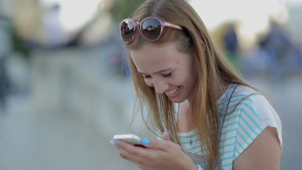Happy Girl Using a Smart Phone in a City Embankment Sitting alt