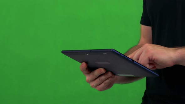 Young Man Works on Tablet - Green Screen - Studio - Closeup alt