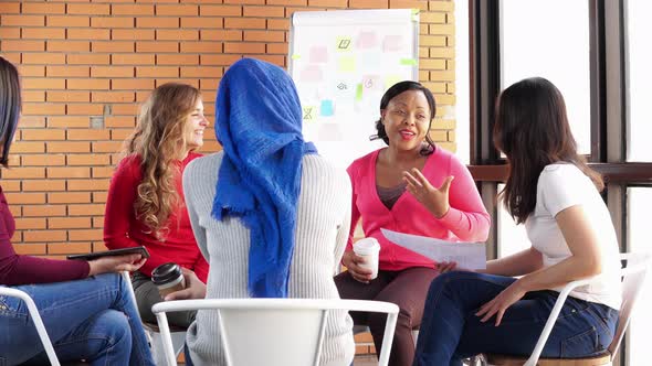 International diverse women sitting together talking and sharing in group meeting