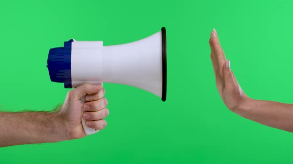 A Man's Hand is Holding a White Megaphone and a Woman's Hand is Making a Stop Sign Against the alt