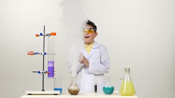 Little Boy Chemist in Uniform, Protective Glasses Has Successfully Tested the New Formula alt