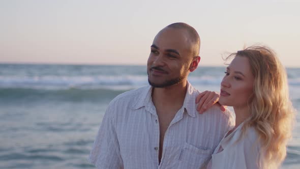 Young Beautiful Couple in Love Standing and Hugging on Beach By the Sea