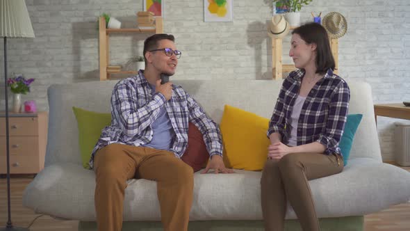 a Man Communicates with a Young Woman Sitting on the Couch Uses Speech Aid alt