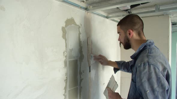 Friendly Male Builder Spreading Plaster on Wall