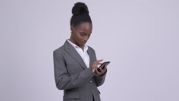 Young African Businesswoman Using Phone and Looking Shocked alt