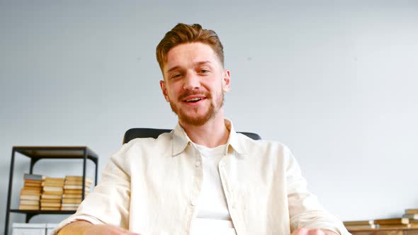 Angry bearded company manager in yellow shirt talks at online meeting alt