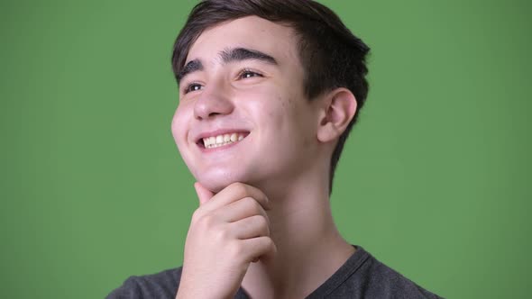 Young Handsome Iranian Teenage Boy Against Green Background alt