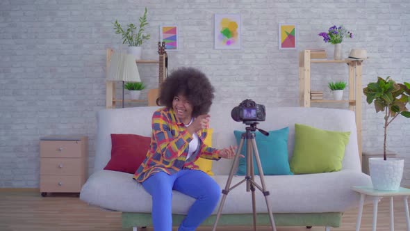 African Woman Blogger with an Afro Hairstyle Before the Camera alt