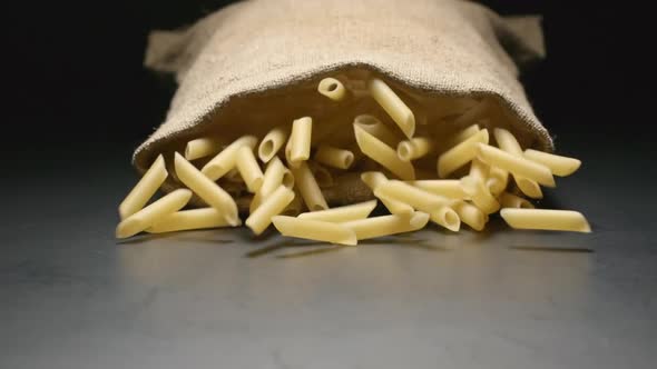 Cloth bag falls and pasta (penne rigate) fall out of him