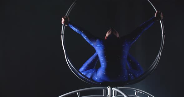 Woman is Balancing in a Big Spinning Hoop Gymnastics Show in the Studio alt