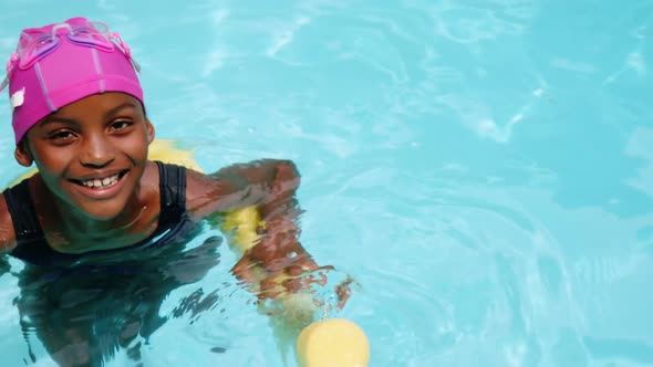 Portrait of young girl swimming with inflatable tube alt