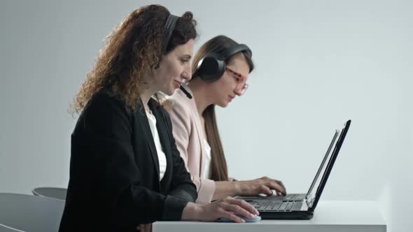 Customer Support Agent or Call Center with Headset Works on Desktop Computer While Supporting the