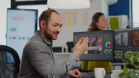 Video Editor Talking on Videocall Holding Smartphone alt