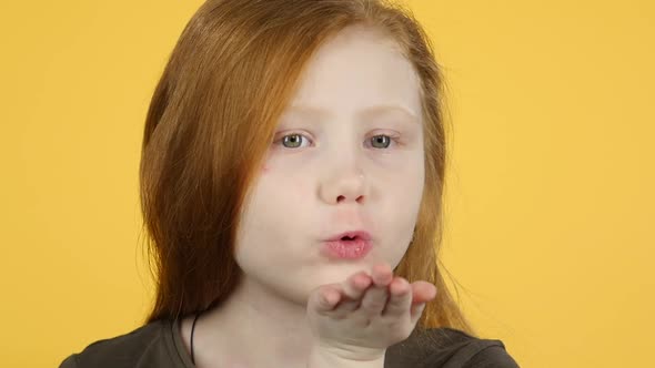 Close-up Red Hair Girl Blows Air Kiss To Someone. Slow Motion alt