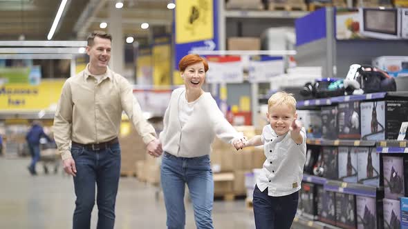 Excited Family with Kid Son Have Fun in Supermarket Running Through Aisles
