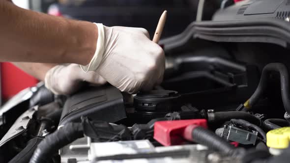 An auto mechanic is cleaning the engine compartment. car service. close-up.