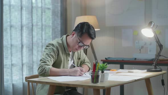 Asian Man Designer Is Drawing On The Layout Bond At The Office alt