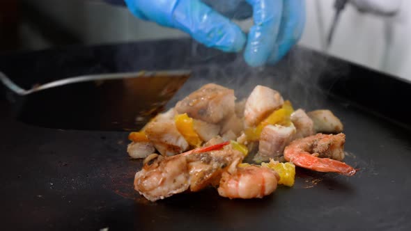 Chef Prepares Seafood with Peaces of Orange on the Grill Closeup