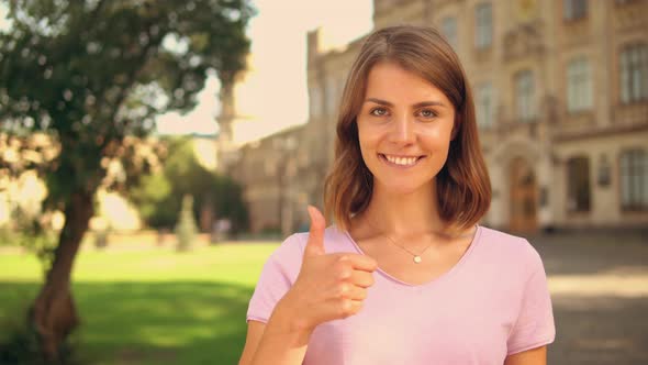 Close Up Young Woman Shows Thumb Up Near College alt