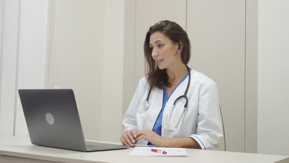 Female Doctor Wear Headset Make Online Video Call Consult Patient alt