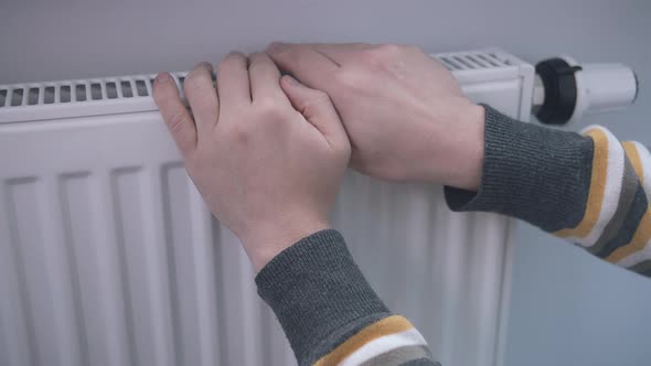 The Male Hand Controls the Heating of the Battery with a Controller