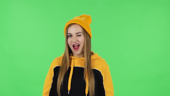 Portrait of Modern Girl in Yellow Hat Is Making Sign Ok. Green Screen alt