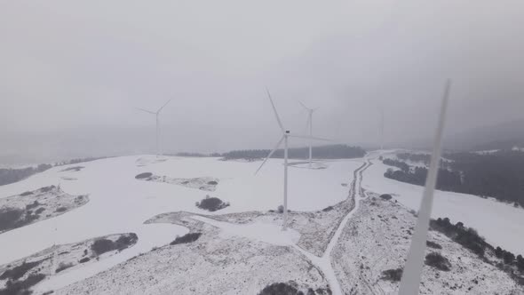 Aerial View of a Wind Farm in Winter Rotating Turbines on a Snowy Field in Ukraine