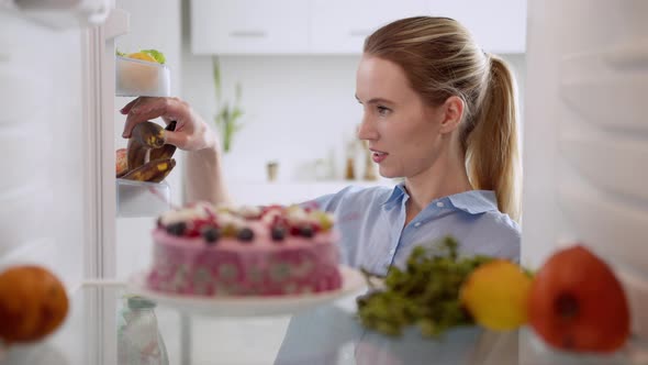 Woman squints because of stench something disgusting, unpleasant smell from her fridge.