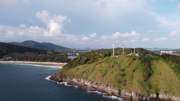 Windmill Sitting on Rocky Tropical Coastline with Stunning Beaches Below