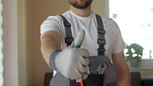 Home Craftsman in Overalls with Tools Shows That Everything is in Order
