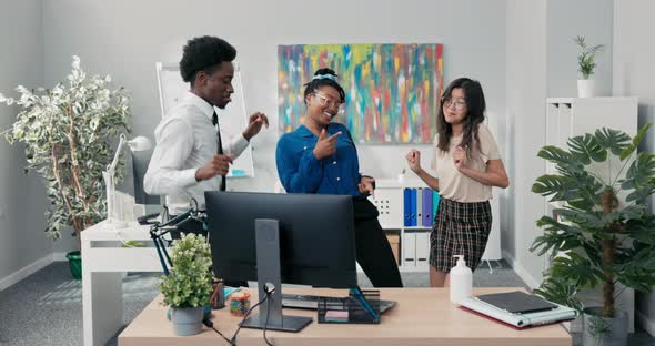 Dance at Work Office Break From Duties Company Party Two Girls and a Man in a Shirt and Tie Dancing alt