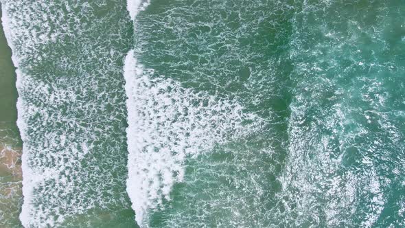Drone view seascape on sunlight and wave crashing to the beach foaming . alt