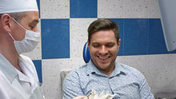 Dentist Explaining Where Having Fillings in Client Mouth alt