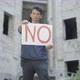 Portrait of Mixed-race Young Man Raising No Poster and Looking at Camera. Rack Focus Changes From - VideoHive Item for Sale