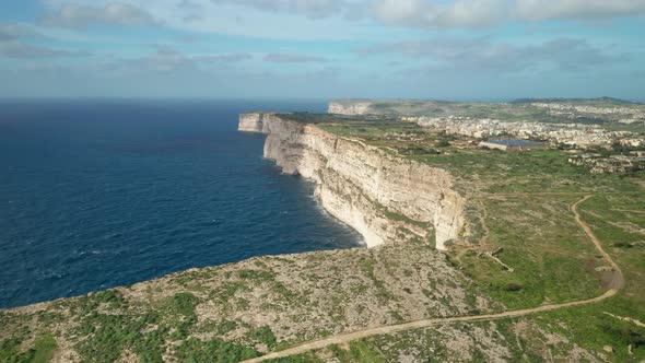 AERIAL: Clouds Cast Shadows on Ta Cenc Cliffs near Blue Mediterranean Sea