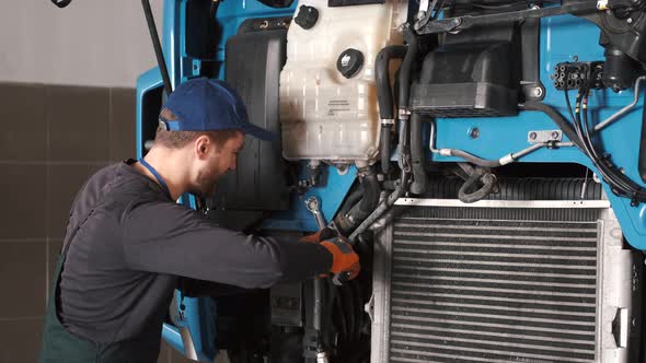 Professional Car Mechanic Check Trucl Engine in Car Garage alt