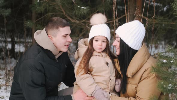 Parents with Daughter Walking in Forest in Winter alt