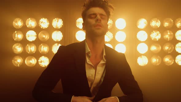 Man Model Wearing Suit Buttoning Jacket in Club Lights alt