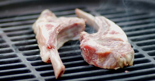Fresh Rack of Lamb on a Barbecue with Smoke. 