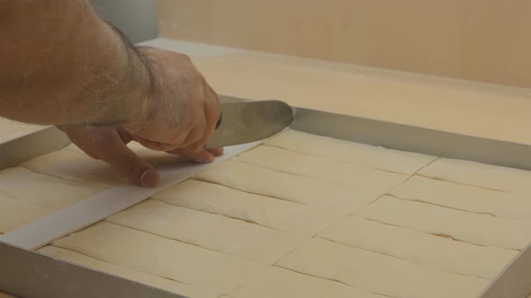 a Baker Uses a Ruler To Cut the Dough for Turkish Baklava