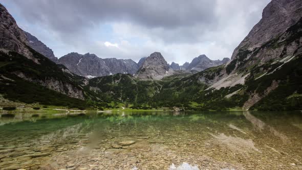 Time Lapse Clouds and Sunrays Move over Mountain Lake in Austrian Alps alt
