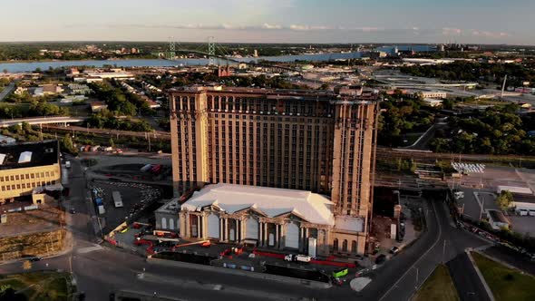 Aerial footage of Michigan Central Station in Detroit during sunset with the Ambassador Bridge and W alt