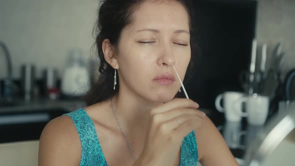 Young Woman Performs a Covid19 Antigen Selftest alt