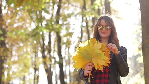 Beautiful teenage girl taking Selfie on smartphone outdoors in Park on Sunny autumn day alt