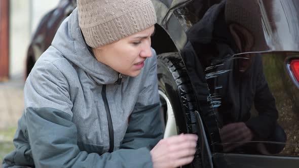 The girl notices fresh scratches on the bumper of the car and is upset alt
