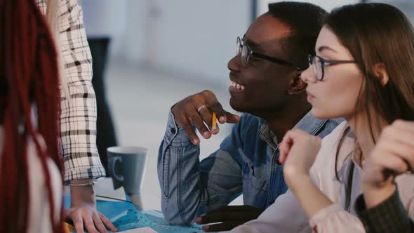 Young Happy Smiling Multiethnic Business Partners Talking, Discussing Work Ideas on Brainstorming alt