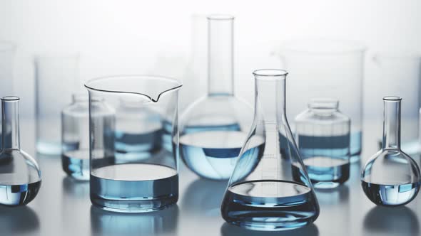 Laboratory glassware with blue liquid inside on a light background. Looping 4KHD