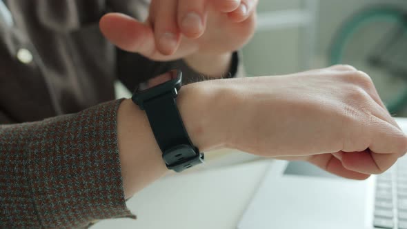 Close-up of Businessman's Hand Touching Smart Watch Screen Swiping Device Display in Office alt