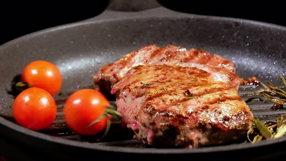 Cherry Tomatoes Are Placed on a Rotating Frying Pan on Which the Meat Steak Is Fried.